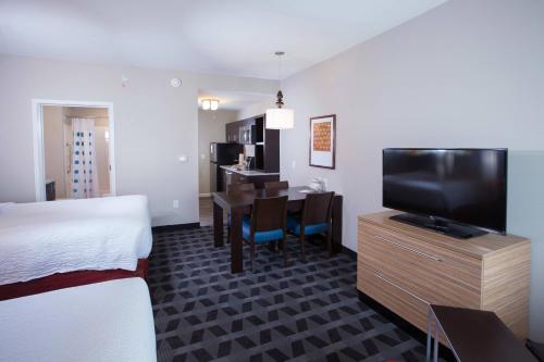 a hotel room with a bed and a dining room at TownePlace Suites by Marriott Southern Pines Aberdeen in Aberdeen