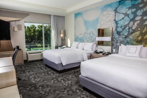 a hotel room with two beds and a large window at Courtyard by Marriott Columbia Cayce in Cayce