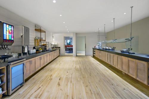 Il comprend une grande cuisine dotée de parquet et d'un grand comptoir. dans l'établissement Residence Inn by Marriott Orlando at FLAMINGO CROSSINGS Town Center, à Orlando