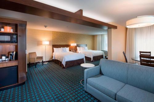 a hotel room with two beds and a couch at Fairfield Inn & Suites by Marriott Scottsbluff in Scottsbluff