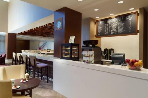 a restaurant with a counter and a bar with chairs at Atlanta Marriott Peachtree Corners in Norcross