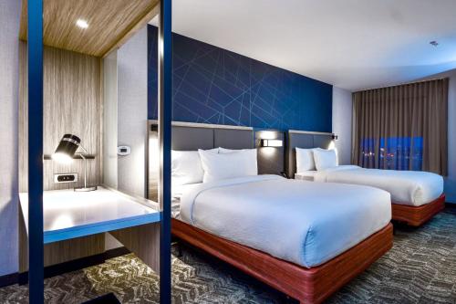 a hotel room with two beds and a blue wall at SpringHill Suites by Marriott Kenosha in Kenosha