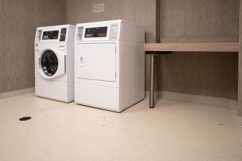 two washing machines sitting next to a table at SpringHill Suites by Marriott Kenosha in Kenosha