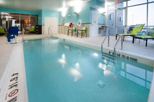a large swimming pool with blue water in a building at SpringHill Suites by Marriott Kenosha in Kenosha