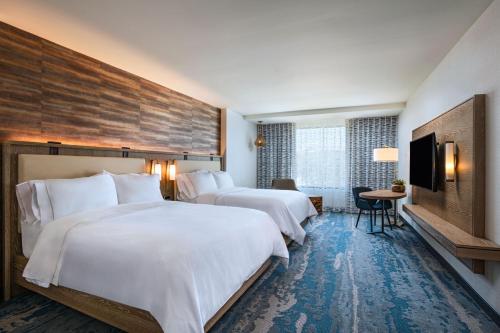 a hotel room with two beds and a flat screen tv at The Westin Dallas Southlake in Southlake