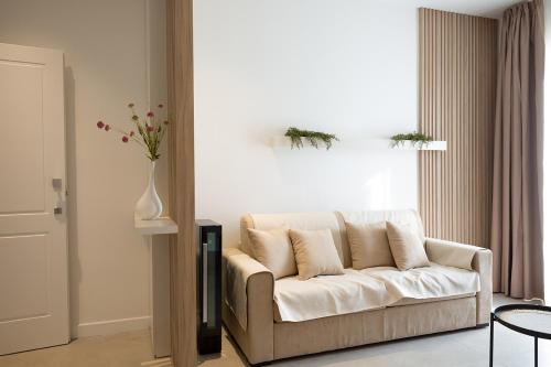 a living room with a white couch and a vase with flowers at Giada Luxury in Terrasini