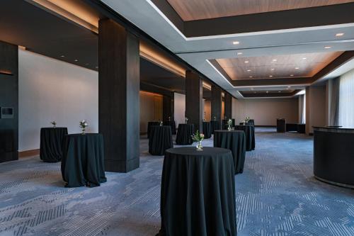 a row of tables in a large room with black tables at The Westin Dallas Southlake in Southlake