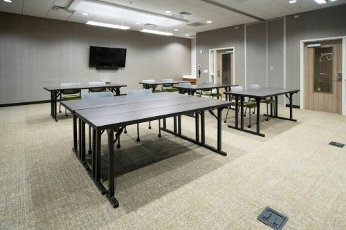 a conference room with tables and a flat screen tv at SpringHill Suites by Marriott Kenosha in Kenosha