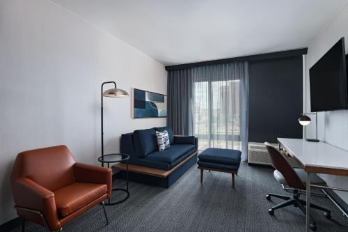 a hotel room with a chair and a desk at Courtyard by Marriott Colorado Springs North, Air Force Academy in Colorado Springs