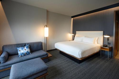a hotel room with a bed and a couch at Courtyard by Marriott Charlotte Waverly in Charlotte