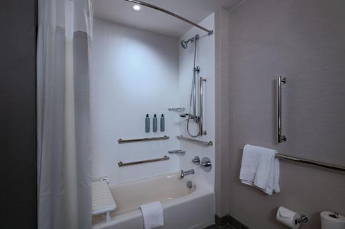 a bathroom with a shower and a tub and a toilet at Courtyard by Marriott Colorado Springs North, Air Force Academy in Colorado Springs