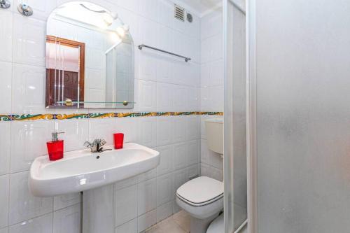 a white bathroom with a sink and a toilet at Beach, surf and golf apartment near Lisbon in Aroeira