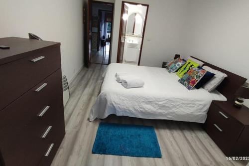 a bedroom with a bed and a dresser and a mirror at Beach, surf and golf apartment near Lisbon in Aroeira