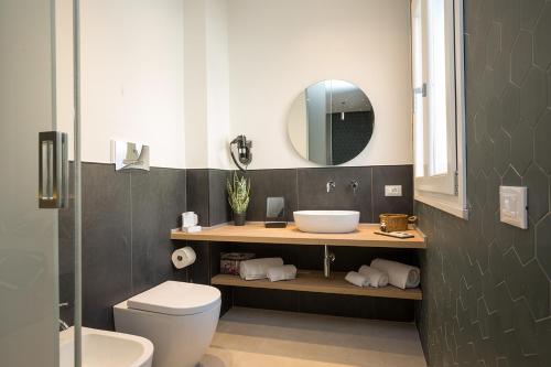 a bathroom with a sink and a toilet and a mirror at Giada Luxury in Terrasini