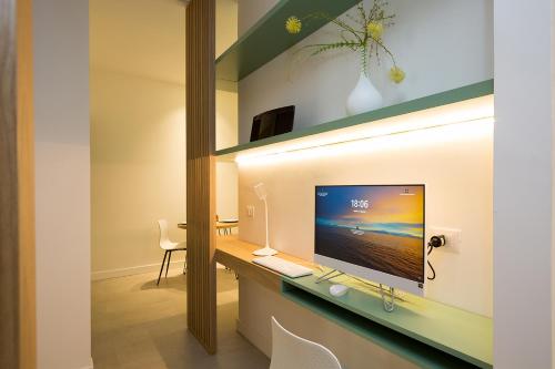a room with a desk with a television on a wall at Giada Luxury in Terrasini