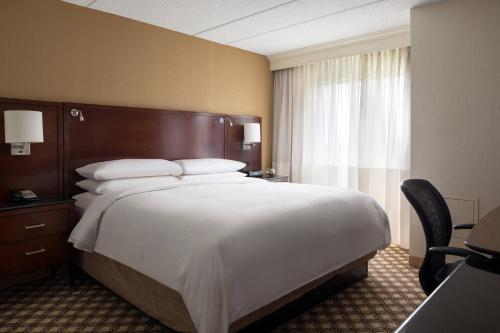 a hotel room with a large bed and a window at Chicago Marriott Naperville in Naperville