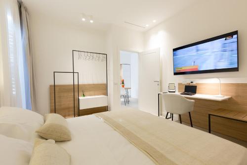 a bedroom with a bed and a desk and a television at Giada Luxury in Terrasini