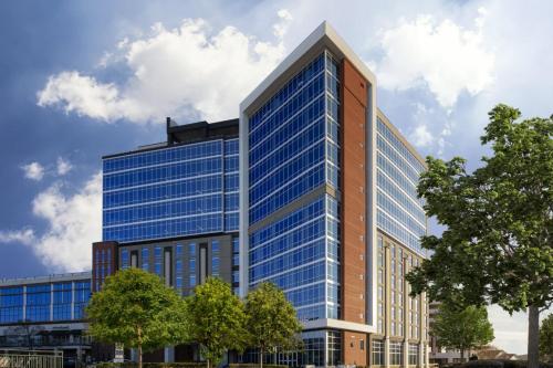 an office building with blue windows at AC Hotel by Marriott Charlotte Ballantyne in Charlotte