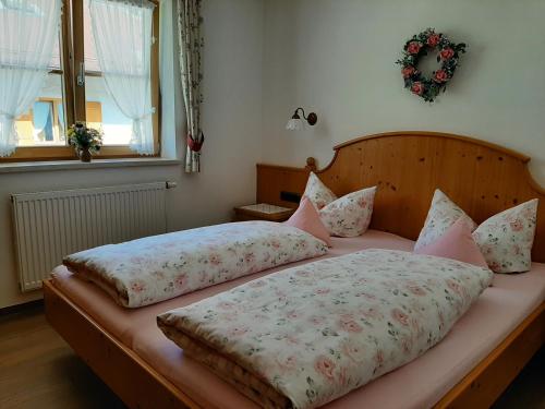 a bedroom with a large bed with a wreath on the wall at Landhaus Bergkristall - Sommer Bergbahnen inklusive in Oberstdorf