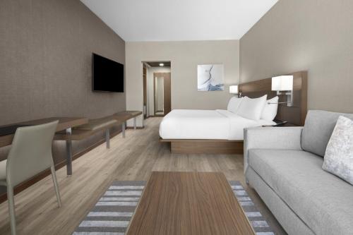 a hotel room with a bed and a desk at AC Hotel by Marriott Charlotte Ballantyne in Charlotte