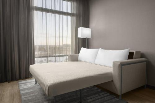 a bedroom with a bed with a large window at AC Hotel by Marriott Charlotte Ballantyne in Charlotte