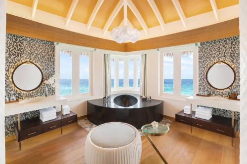 ein Badezimmer mit einer großen Badewanne mit zwei Spiegeln in der Unterkunft JW Marriott Maldives Resort & Spa in Funadhoo