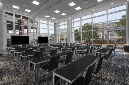 a large room with tables and chairs and windows at AC Hotel by Marriott Charlotte Ballantyne in Charlotte