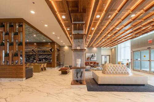 a lobby with a couch and chairs in a building at Delta Hotels by Marriott Raleigh-Durham at Research Triangle Park in Durham
