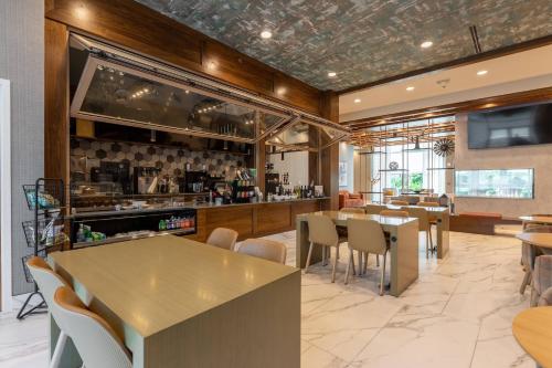 a restaurant with tables and chairs and a bar at Delta Hotels by Marriott Raleigh-Durham at Research Triangle Park in Durham