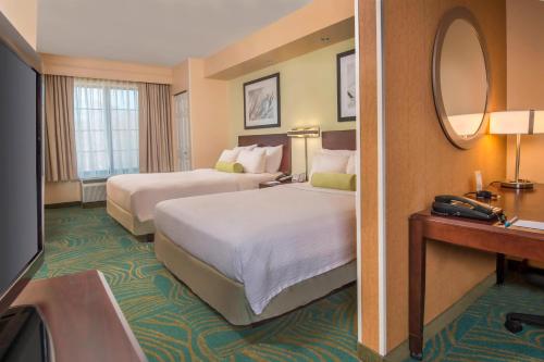 a hotel room with two beds and a mirror at SpringHill Suites Prince Frederick in Prince Frederick