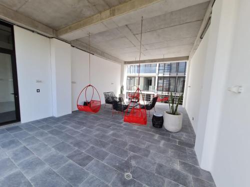 an empty office with red chairs and tables in a room at Apartamento moderno 2 habitaciones y 2 baños area Cayala y Embajada USA in Guatemala