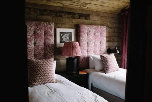 a bedroom with two beds and a lamp on a table at The Artist's House at Jupiter Artland in Kirknewton