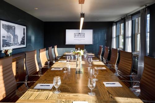 a long table in a room with chairs and a screen at The Barfield, Autograph Collection in Amarillo