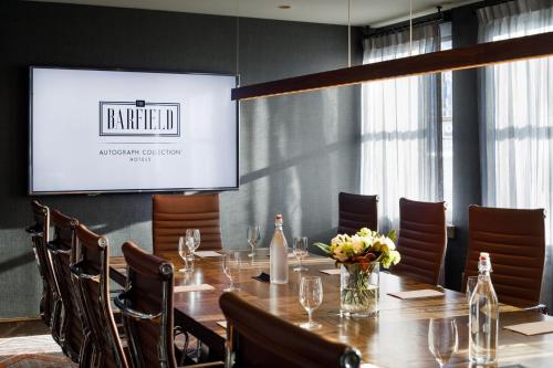 a conference room with a table and chairs and a screen at The Barfield, Autograph Collection in Amarillo
