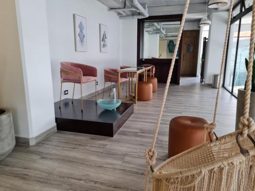 a room with a rope swing and chairs and a table at Apartamento moderno 2 habitaciones y 2 baños area Cayala y Embajada USA in Guatemala