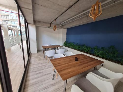 a meeting room with tables and white chairs at Apartamento moderno 2 habitaciones y 2 baños area Cayala y Embajada USA in Guatemala