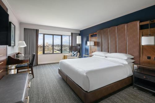 a hotel room with a large bed and a desk at Boston Marriott Long Wharf in Boston