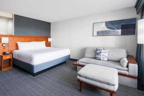um quarto de hotel com uma cama e uma cadeira em Courtyard Hartford Farmington em Farmington