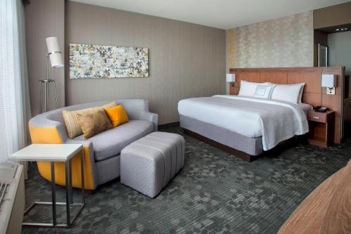 a hotel room with a bed and a couch at Courtyard by Marriott Philadelphia Lansdale in Lansdale