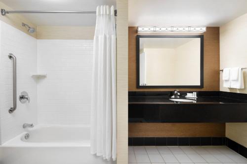 a bathroom with a tub and a sink and a mirror at Fairfield Inn and Suites by Marriott Plainville in Plainville
