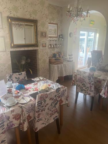 a dining room with tables and chairs and a fireplace at Jasmine House in Newquay