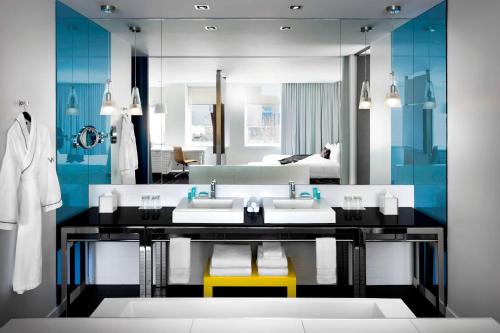 a bathroom with two sinks and a large mirror at W Montreal in Montreal