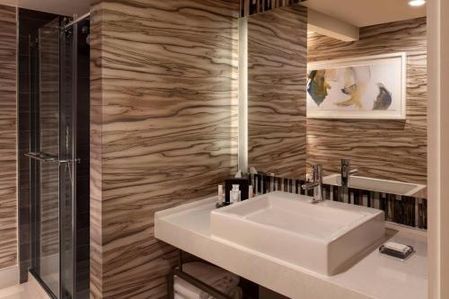 y baño con lavabo blanco y ducha. en Marriott Raleigh Durham Research Triangle Park, en Durham