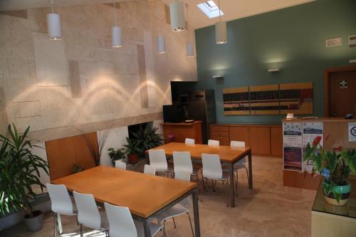 a conference room with tables and white chairs at Hotel Poggio Bertino in Montemerano