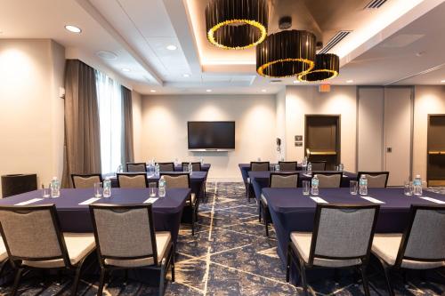 a conference room with tables and chairs and a flat screen tv at Residence Inn Palm Beach Gardens in Palm Beach Gardens