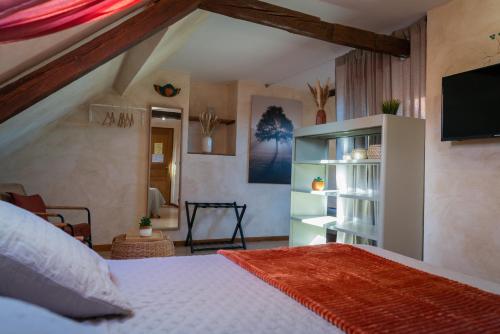 a bedroom with a bed with a tv on the wall at Chambres Du Marais in Tilques