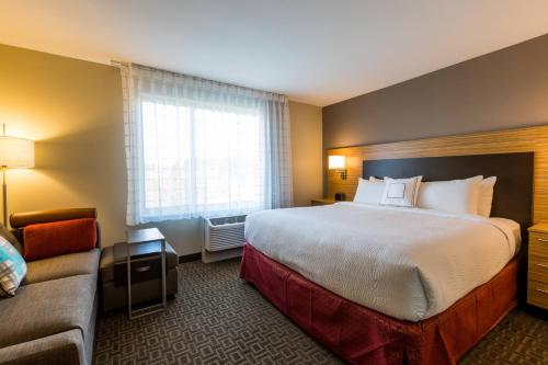 ein Hotelzimmer mit einem großen Bett und einem Sofa in der Unterkunft TownePlace Suites by Marriott Portland Beaverton in Beaverton