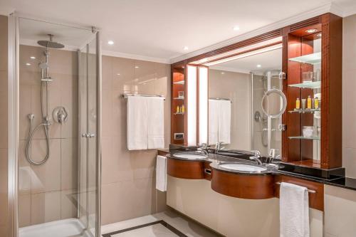 a bathroom with two sinks and a shower at Munich Marriott Hotel in Munich