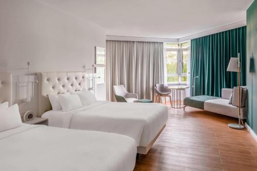 ein Hotelzimmer mit 2 Betten, einem Tisch und Stühlen in der Unterkunft Munich Marriott Hotel in München