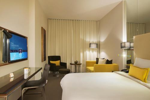 um quarto de hotel com uma cama e uma televisão em Centro Waha by Rotana em Riyadh